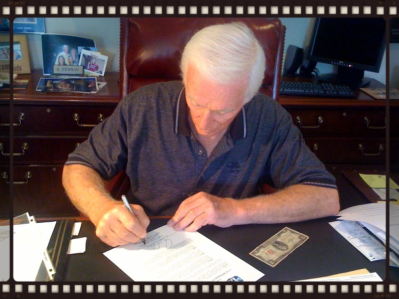 Captain Eugene A. Cernan signs the formal letter of flight certification, attesting the $2 bills history and 3x flight status. The signing took place in his study in Texas in August, 2010 -- after 44 years in his possession.