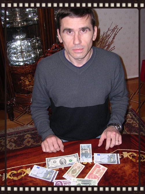 Yuri with examples of flown currency from his ISS 7 mission, including one of the examples of the flown $2 bills.