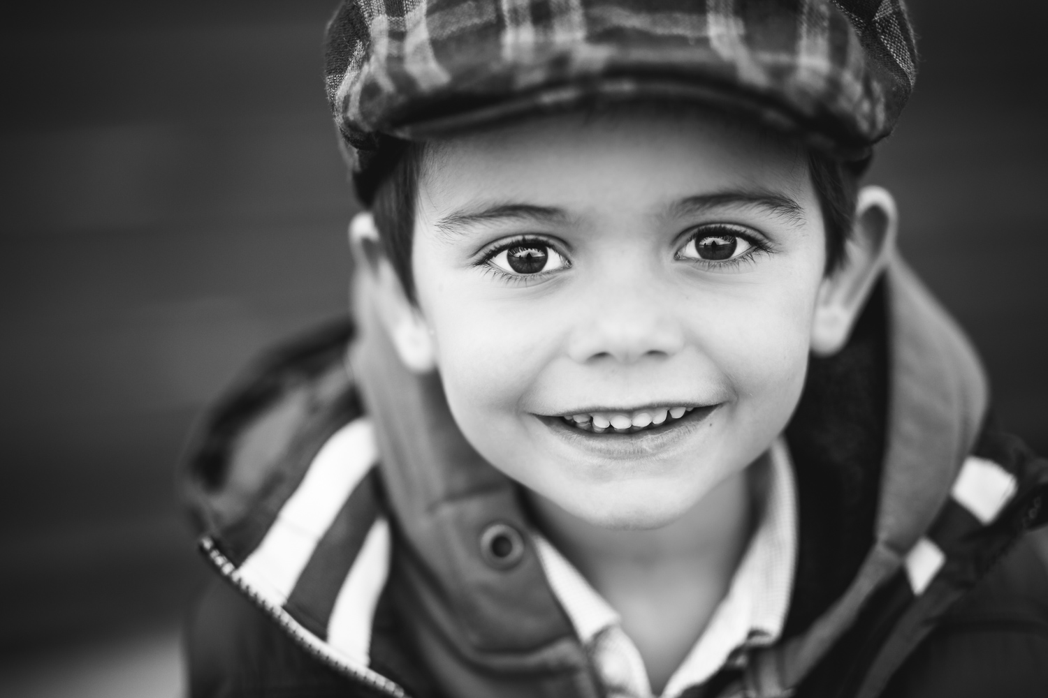 Black-and-white-photo-of-a-young-boy-in-a-cap-by-Stockholm-family-photographer.jpg