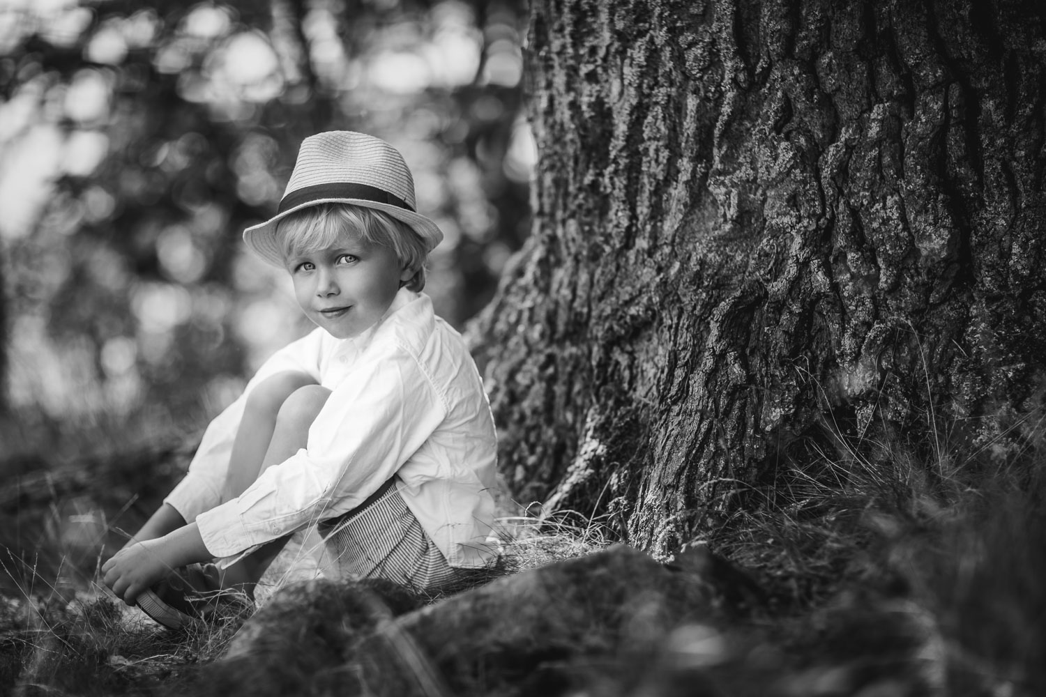 A-black-and-white-portrait-of-a-little-boy-in-a-straw-hat-by-Sandra-Jolly-familjefotograf.jpg