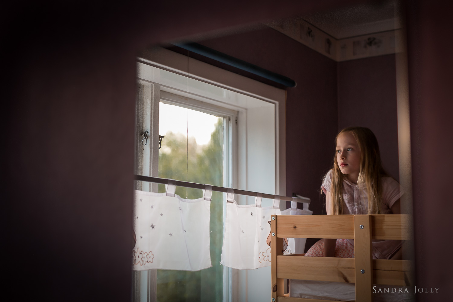 Girl-looking-out-window-familjefotografering.jpg