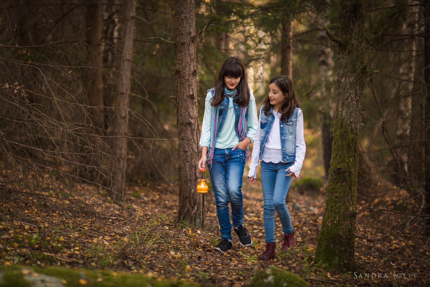 sisters-walking-in-woods-with-candle-by-Sandra-Jolly-familjefotografering.jpg