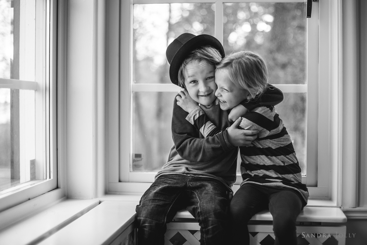 siblings-hugging-in-a-window-Täby-familjefotograf.jpg