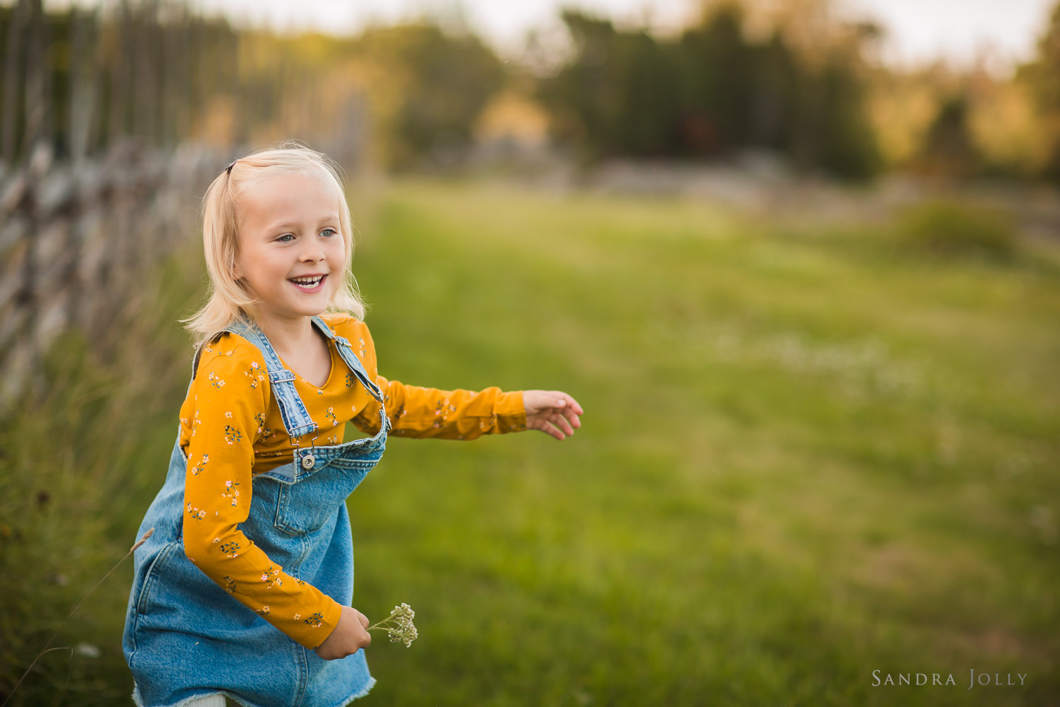 happy-girl-in-field-by-stockholm-barnfotograf-sandra-jolly.jpg