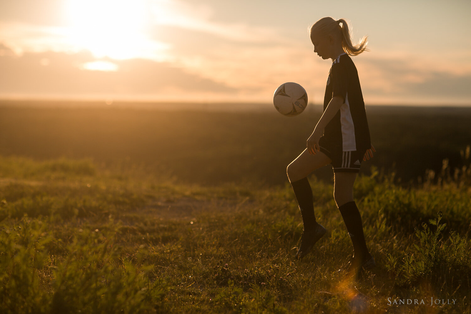 girl-playing-football-at-sunset-by-family-photographer-sandra-jolly-photography.jpg