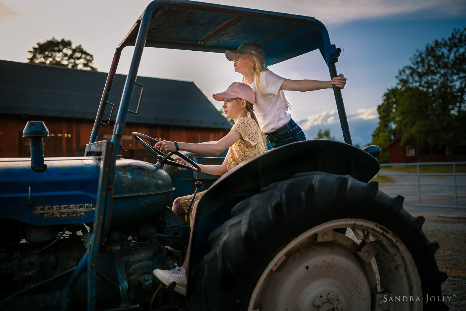 two-sisters-on-a-tractor-at-a-farm-by-stockholm-photographer-sandra-jolly.jpg