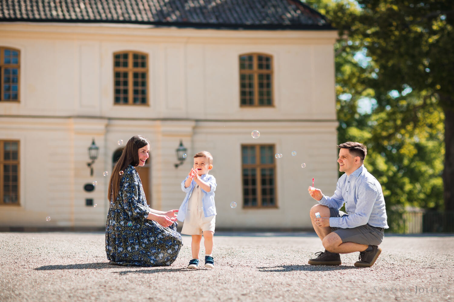 happy-family-blowing-bubbles-at-Drottningholms-slott-by-stockholm-photographer-sandra-jolly.jpg