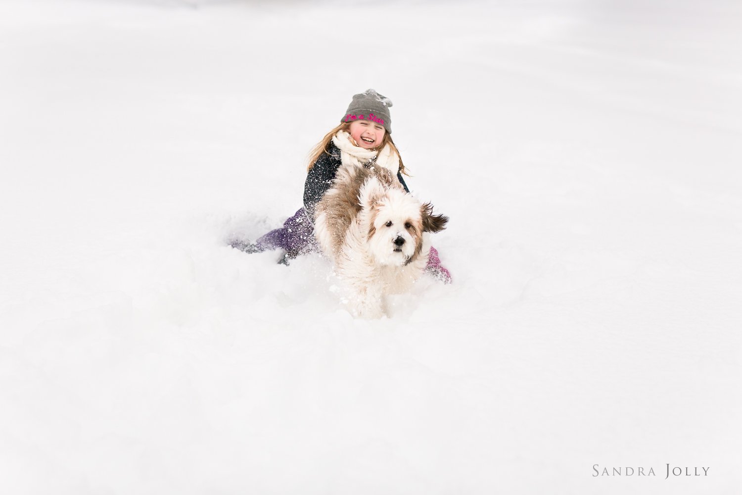 girl-and-dog-playing-in-snow-stockholm-porträttfotograf.jpg