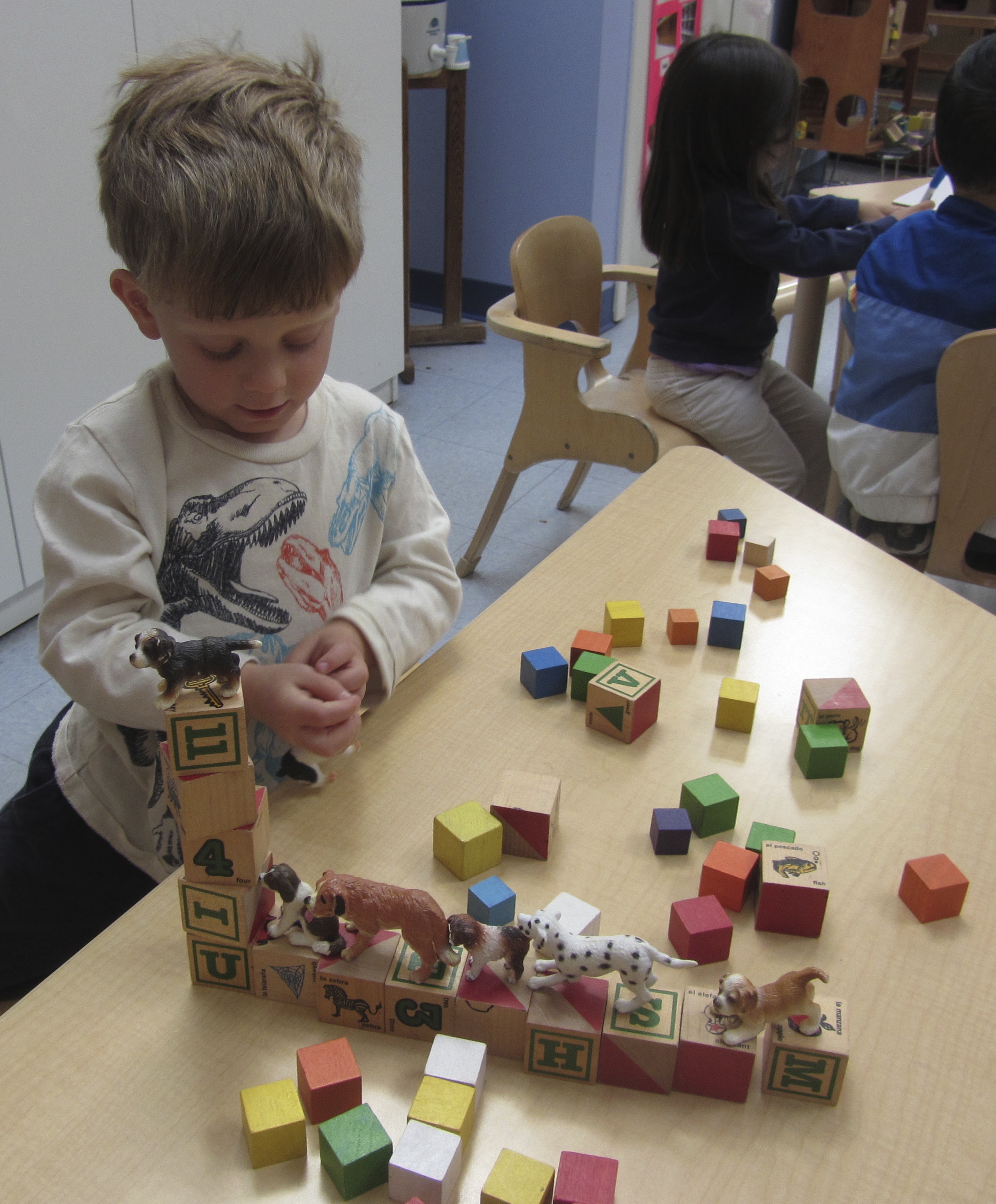 Working with small manipulatives, whether they are blocks, building toys, or small figures, spurs the imagination and tests developing fine motor skills.