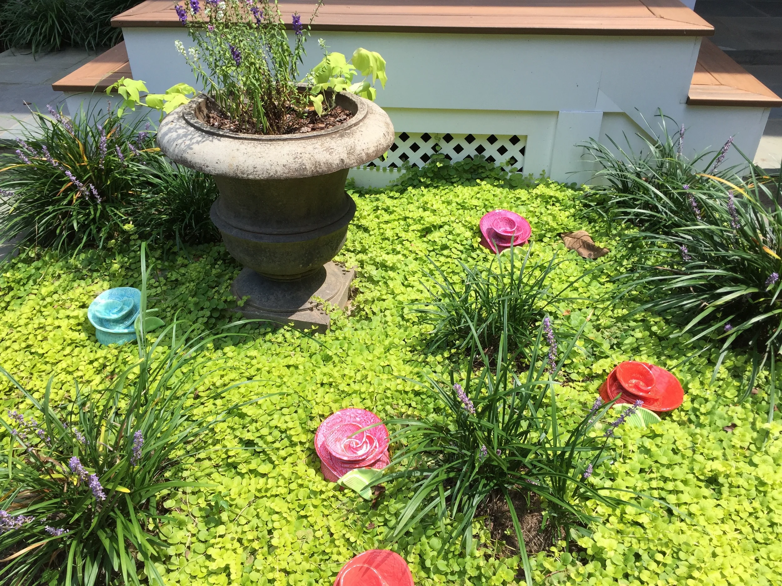 These toad houses bring a pop of color to this beautiful garden area!