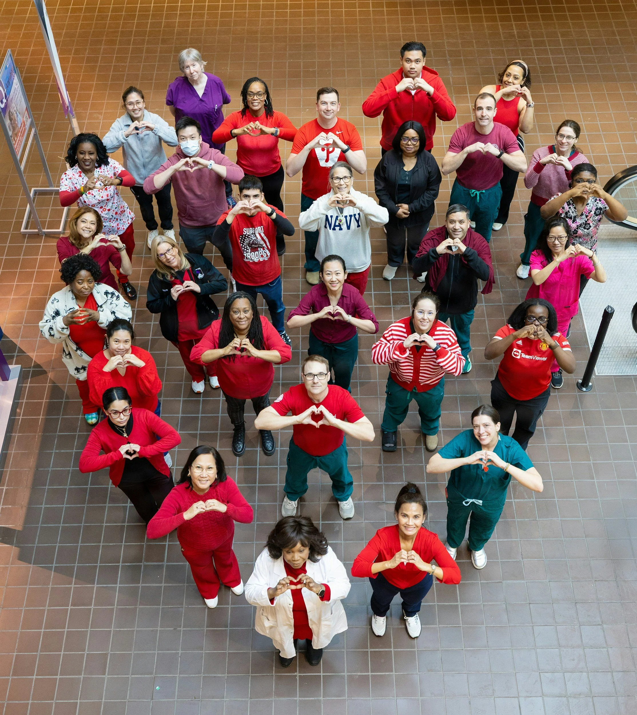 Image of a group of staff working for a chief medical officer standing in the shape of a heart