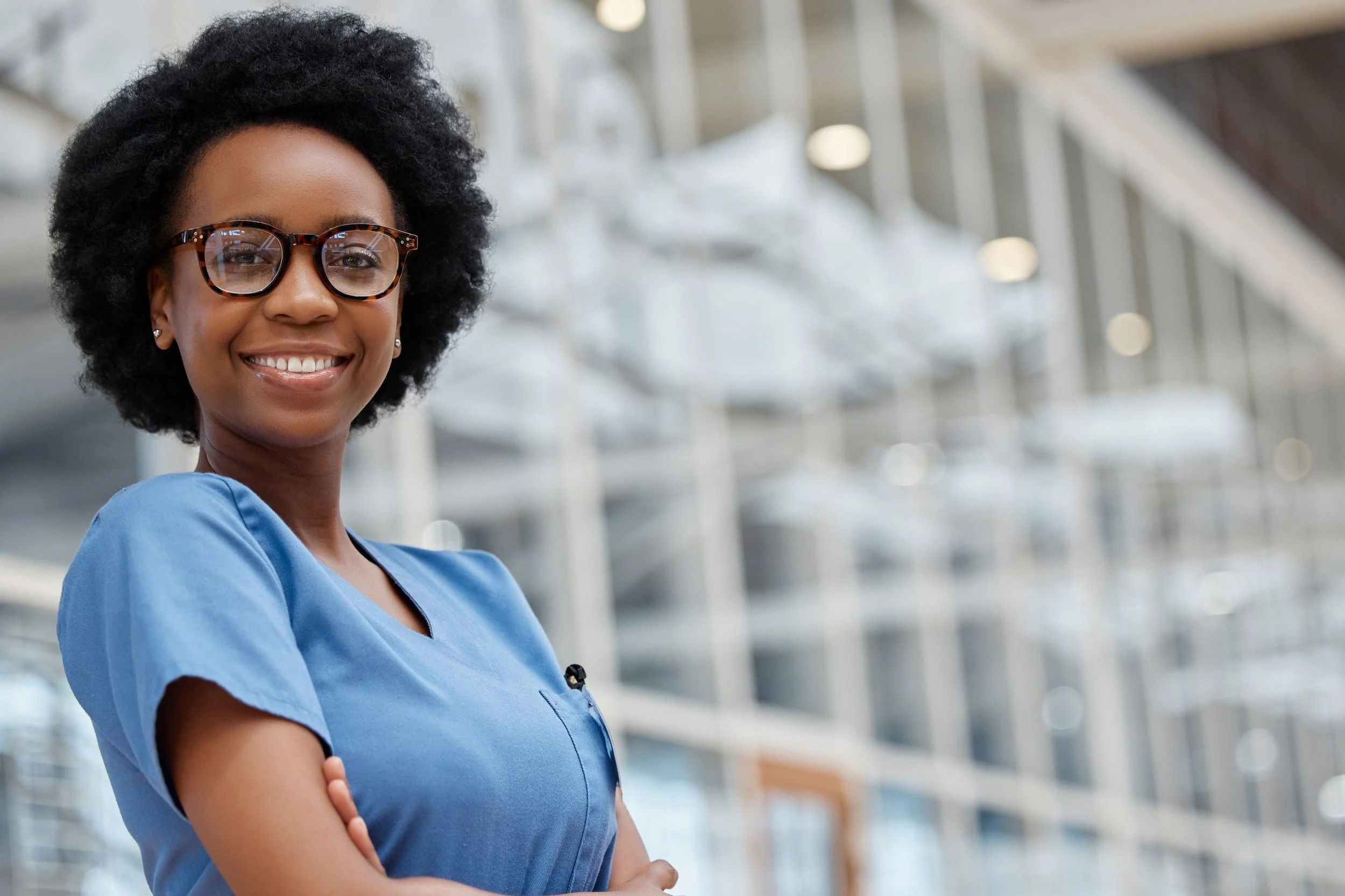 Image of nurse smiling in front of a hospital