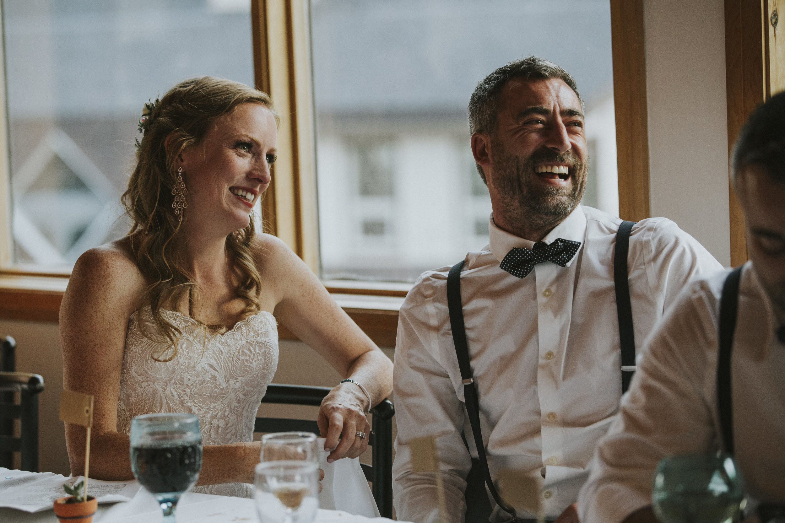bride and groom laugh during speeches mt norquay wedding reception