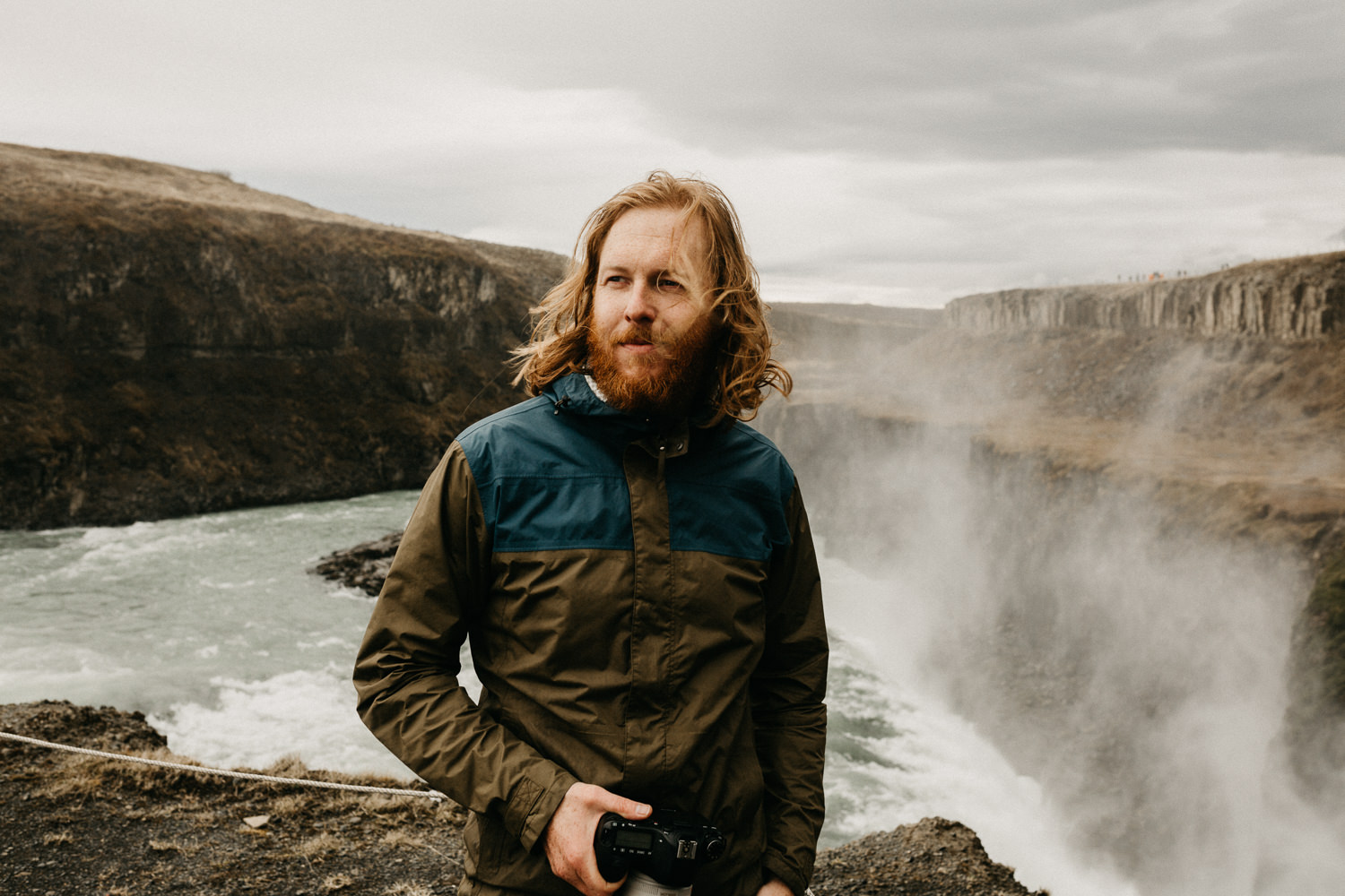 man stands near edge of gullfoss waterfall iceland