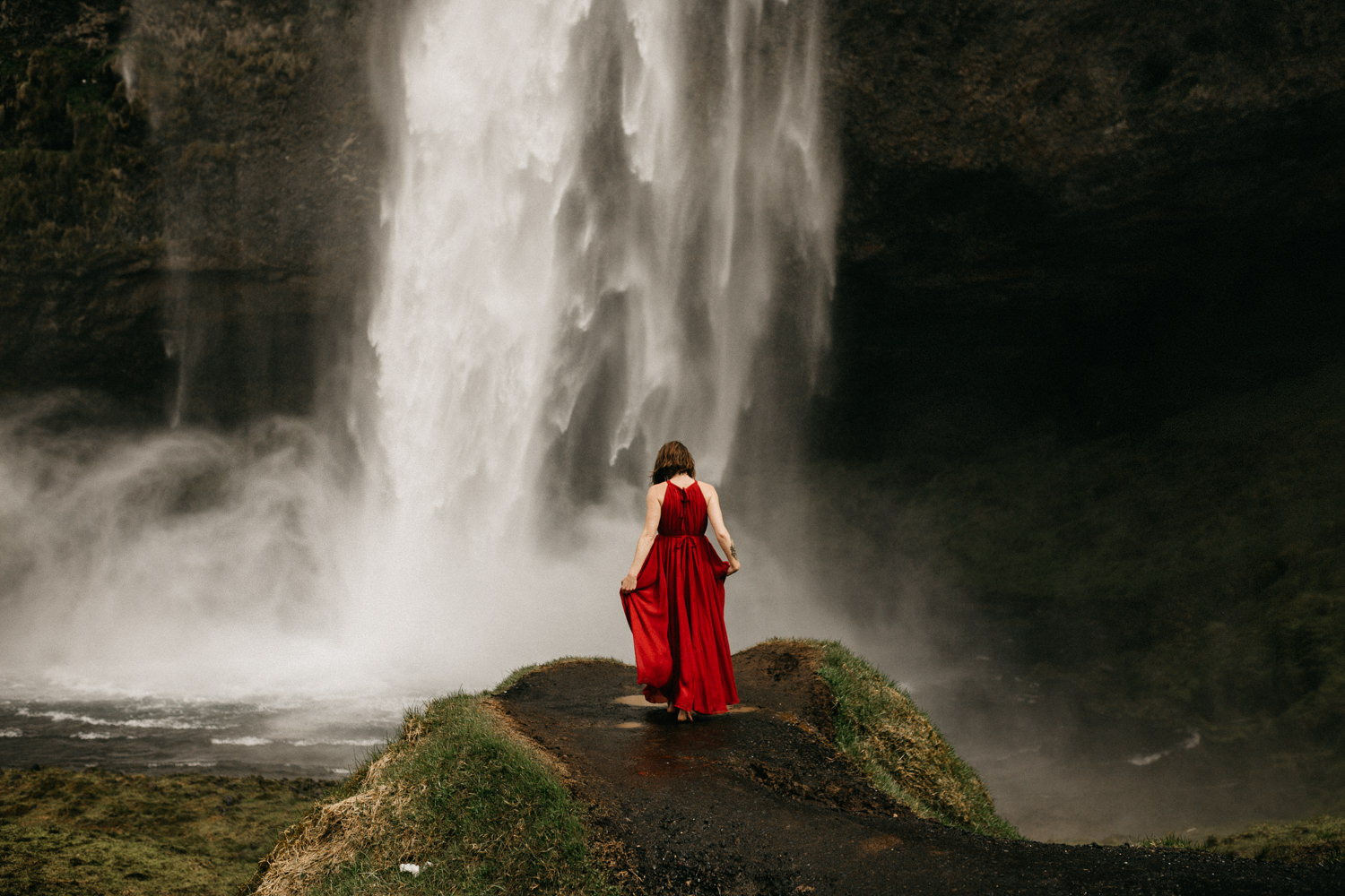 women in red dress at waterfall iceland