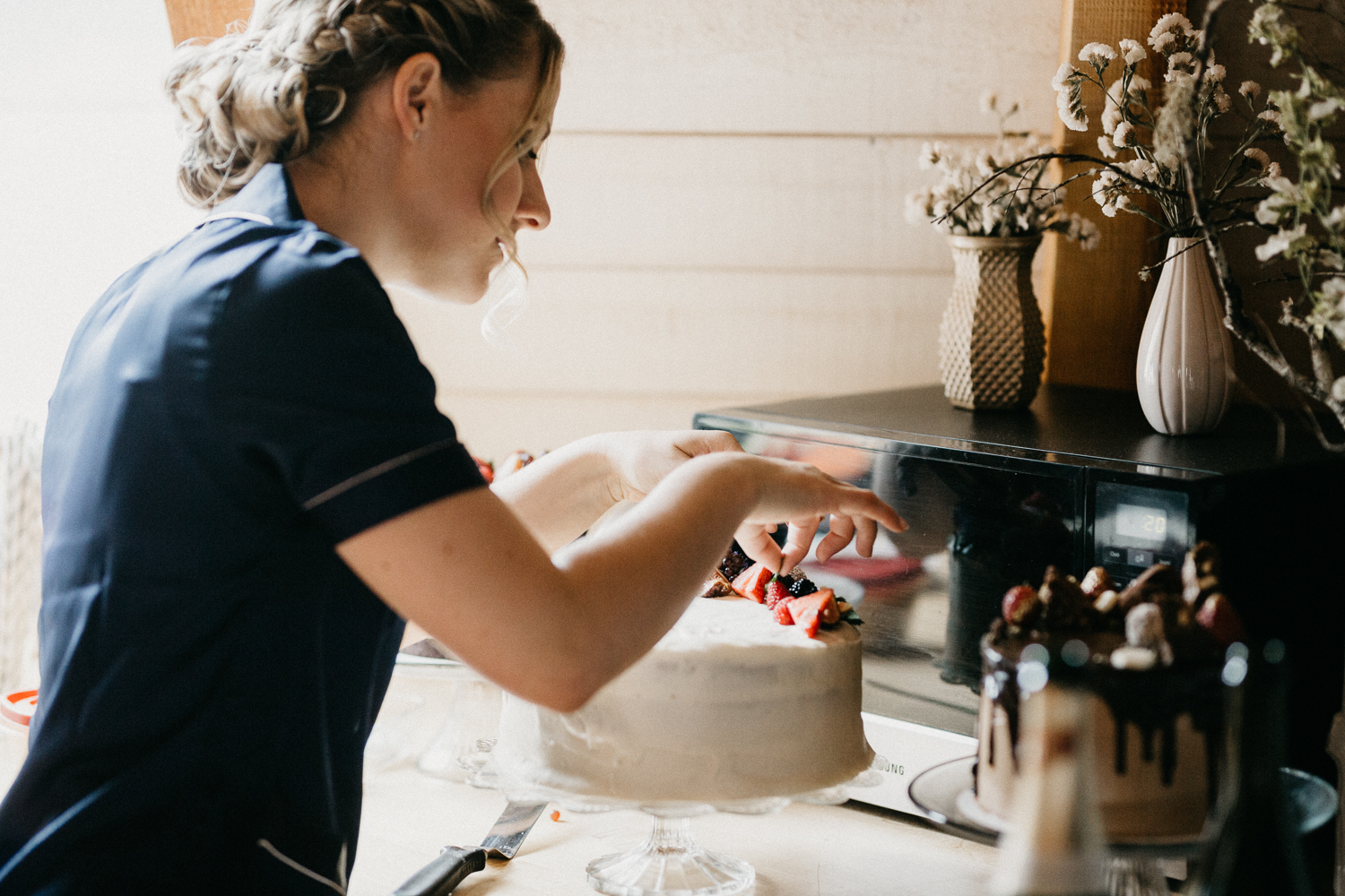 bridesmaid decorating cake at Bird's Eye Cove wedding, Vancouver Island wedding photographer