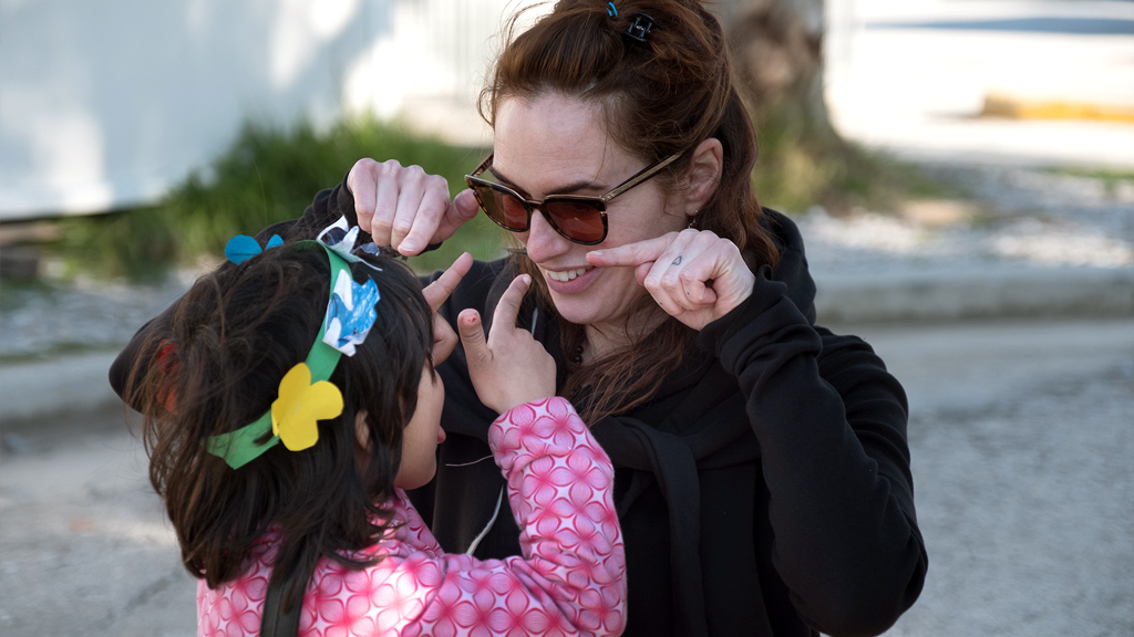 Headey played with an Afghan girl at Kara Tepe. (Jodi Hilton/International Rescue Committee)