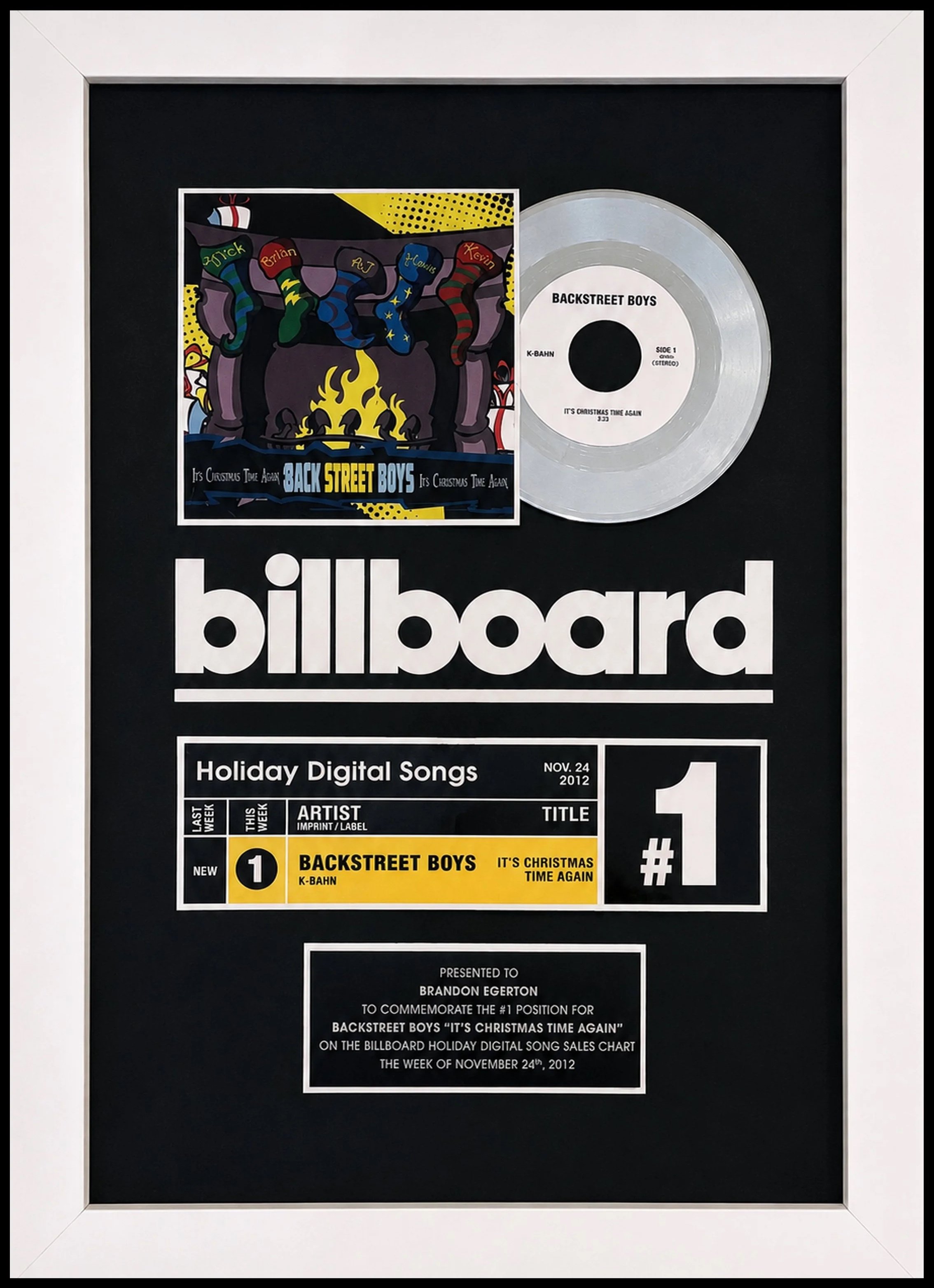 Billboard framed award celebrating Backstreet Boys' song 'It's Christmas Time Again' as number one on holiday digital sales chart for the week of November 24, 2012. Album art features Christmas stockings, a fireplace. Presented to Brandon Egerton.