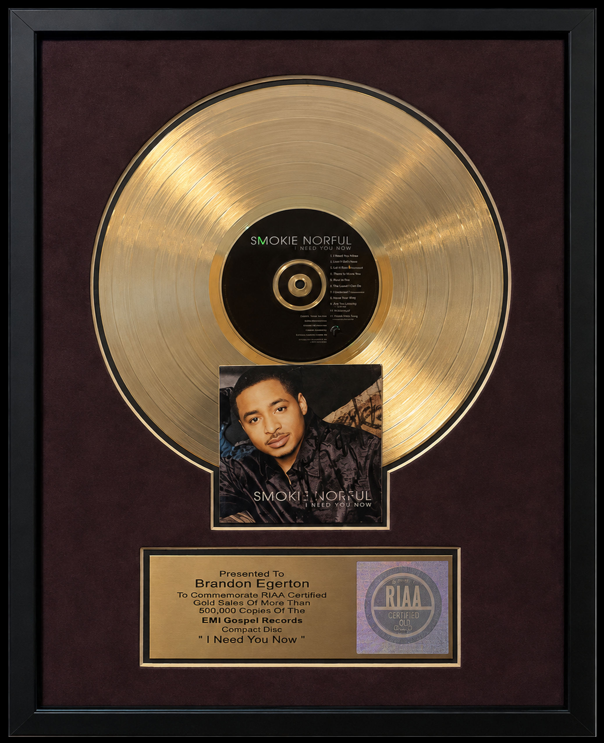 Gold record plaque with a photo of a man and a certificate for Brandon Egerton from EMI Gospel Records for the song "I Need You Now," by Smokie Norful