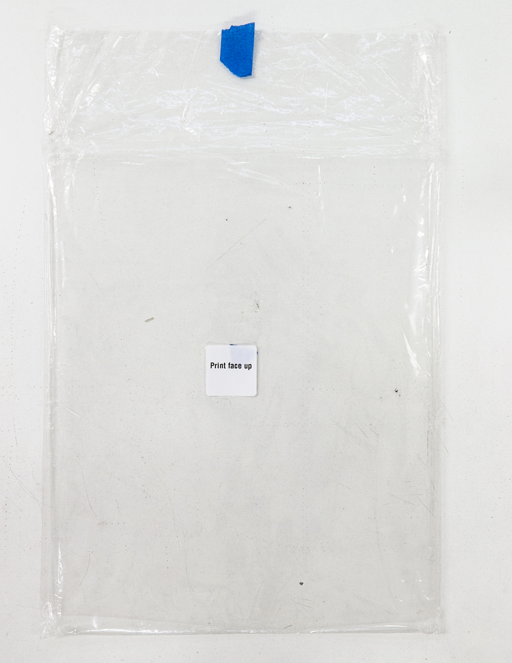 (PRISONTIME/PRISONINME: Transition to Metric) Print Face Up, 2014 Plastic envelope, blue painters tape, text label, approx. 8.5 in. x 11 in.