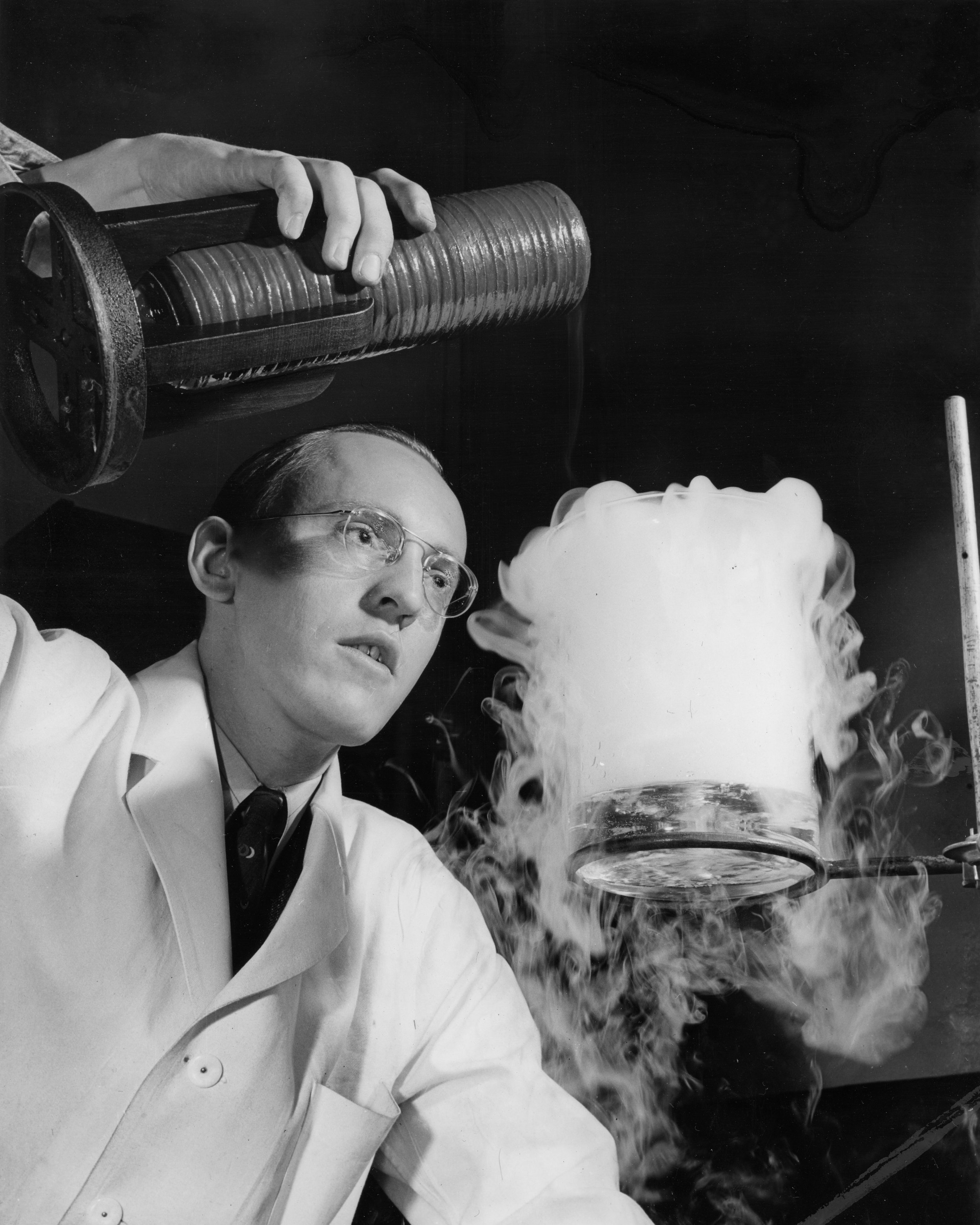 With liquid air and warm water, Research Engineer Arthur M. Stiles manufactures a cloud at the Westinghouse Research Laboratories to test insulating materials for the electrical systems of new bombing planes. Such artificial clouds are easily introduced into the sealed flasks known as altitude chambers where insulating materials can be tested for electrical performance in the presence of clouds and other atmospheric conditions. Even a small snow storm can be reproduced, because when the flask containing the baby cloud is coolers below the freezing point, tiny snow flakes are precipitated into the material under test.