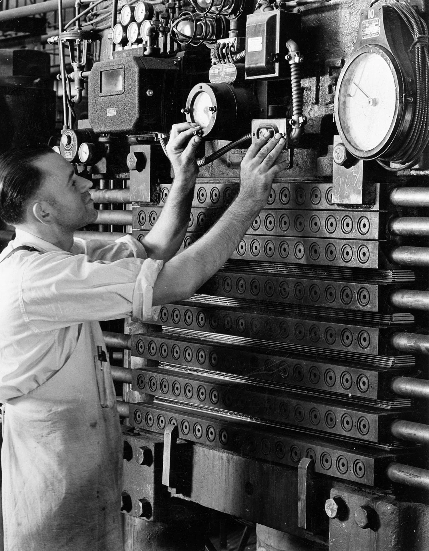 Circa 1944, a Westinghouse hydraulic hot molding press converting treated sheets of paper into 20 Micarta plates measuring 4’ x 8’.