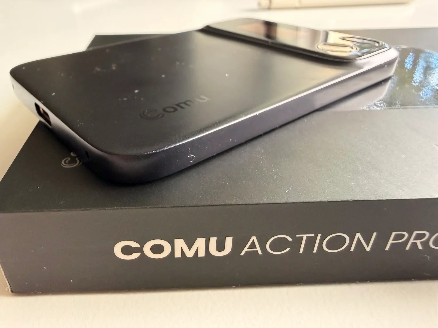 Side view of the Comu Action Pro showing the thickness of the AI recorder on top of its box.