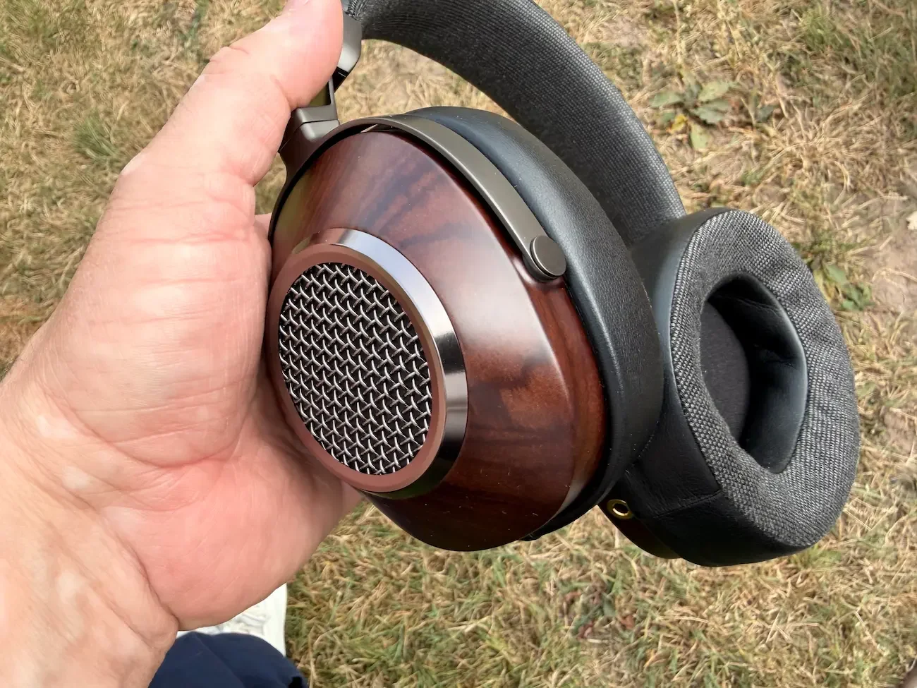 Close-up of the handcrafted wooden ear cup and open-back grille on the SIVGA Anser headphones.