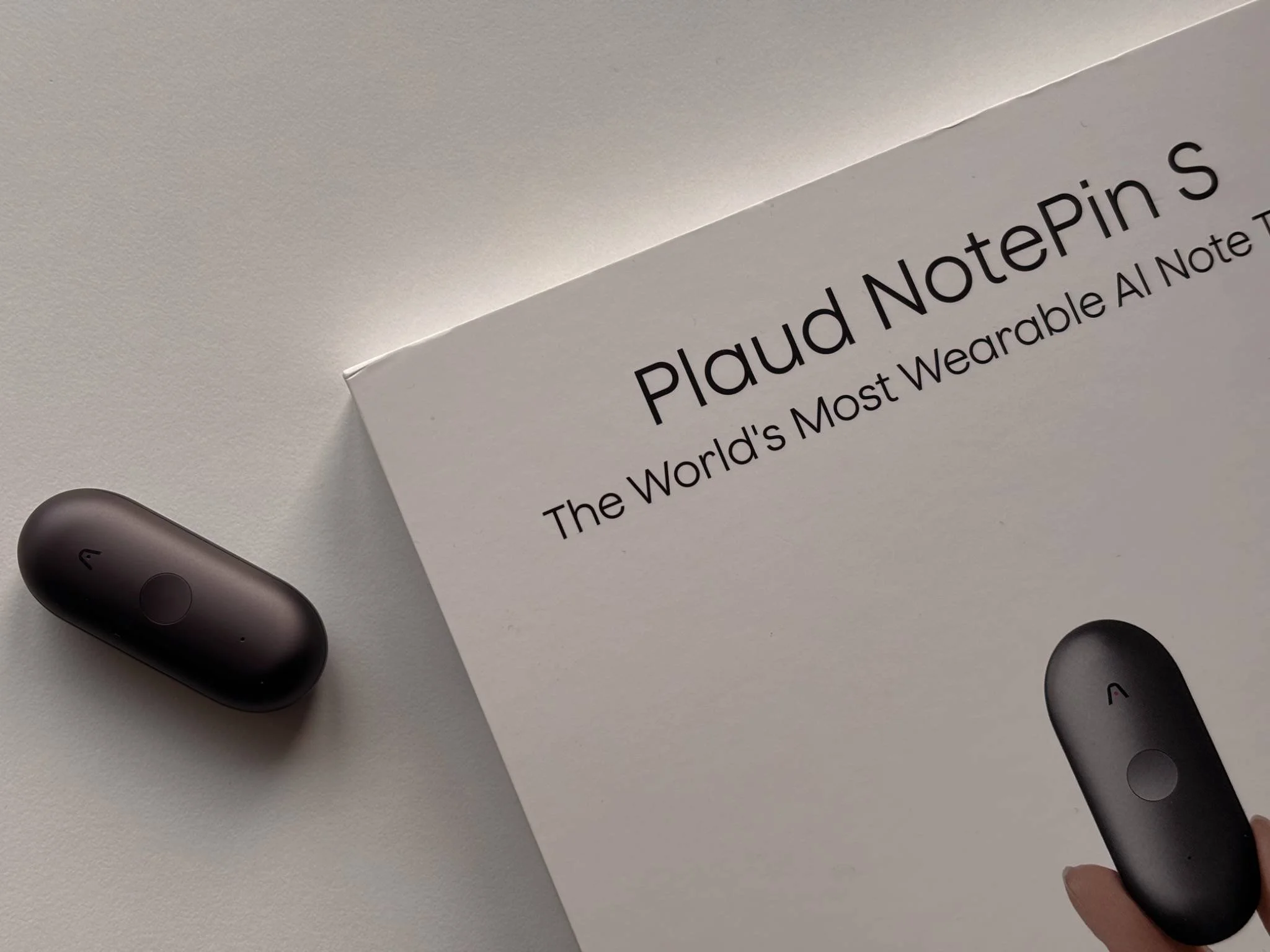 PLAUD NotePin S hero image showing the wearable AI note taker next to its packaging on a clean desk.