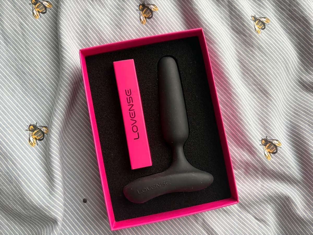 Lovense Glint black vibrating butt plug inside its pink presentation box with foam packaging.
