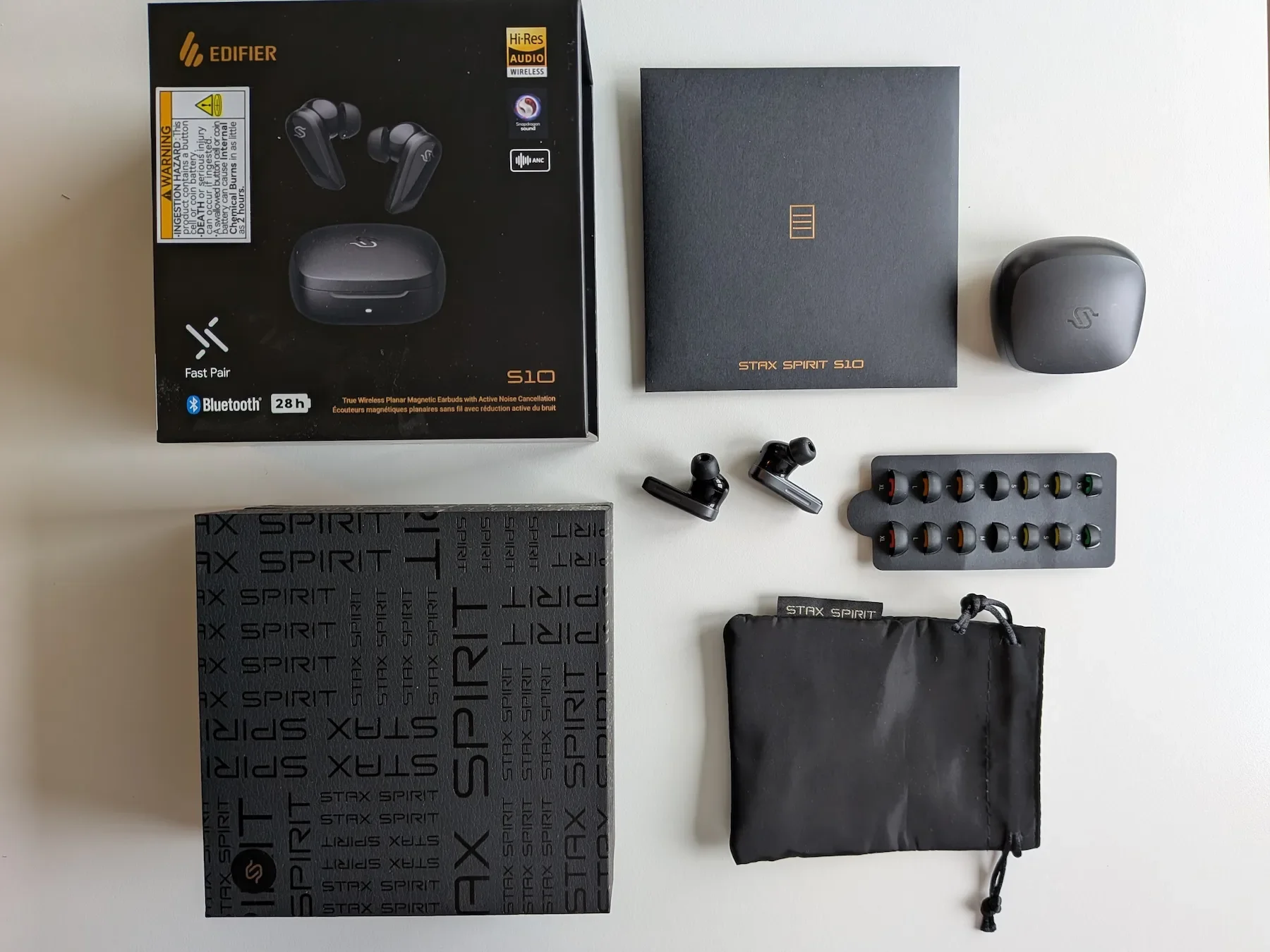 Edifier STAX Spirit S10 box contents laid out on a white surface with case, earbuds, pouch and ear tips