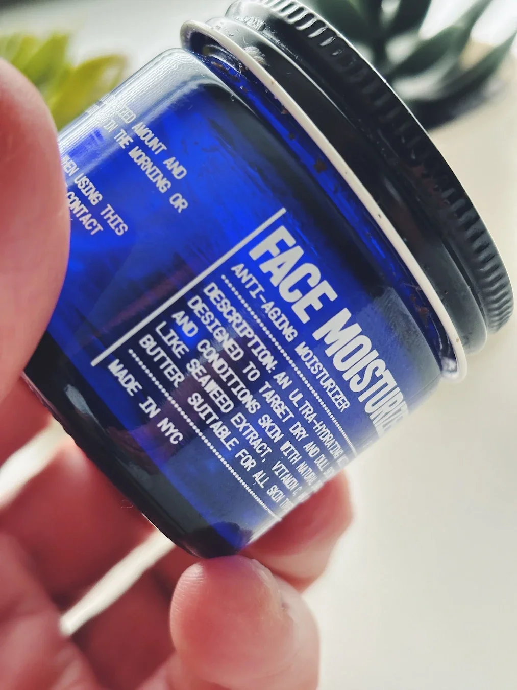 Blu Atlas anti-aging Face Moisturizer jar held close up showing label — best clean face cream for men reviewed by Jerome