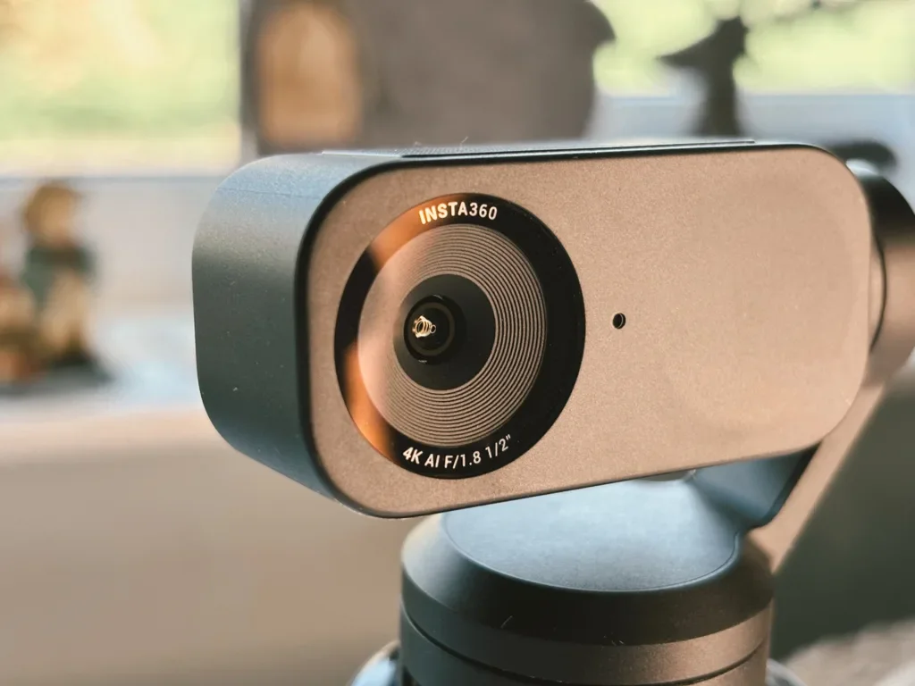 Close-up of the Insta360 Link 2 4K AI webcam lens on its gimbal mount