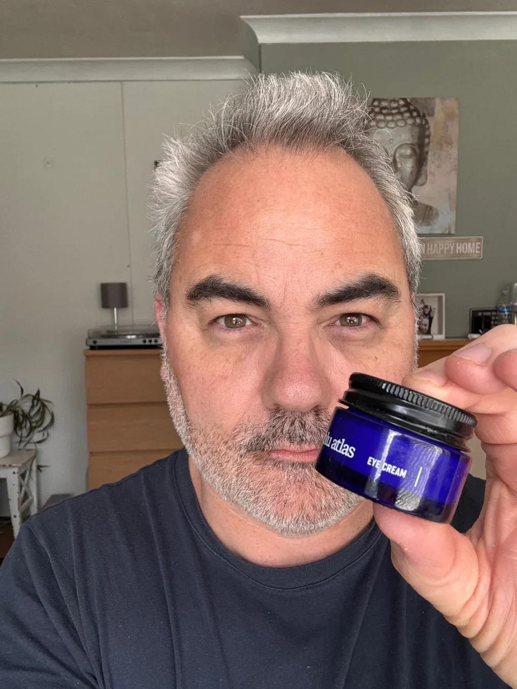 Jerome holding the Blu Atlas Brightening Eye Cream for a 13-year review.