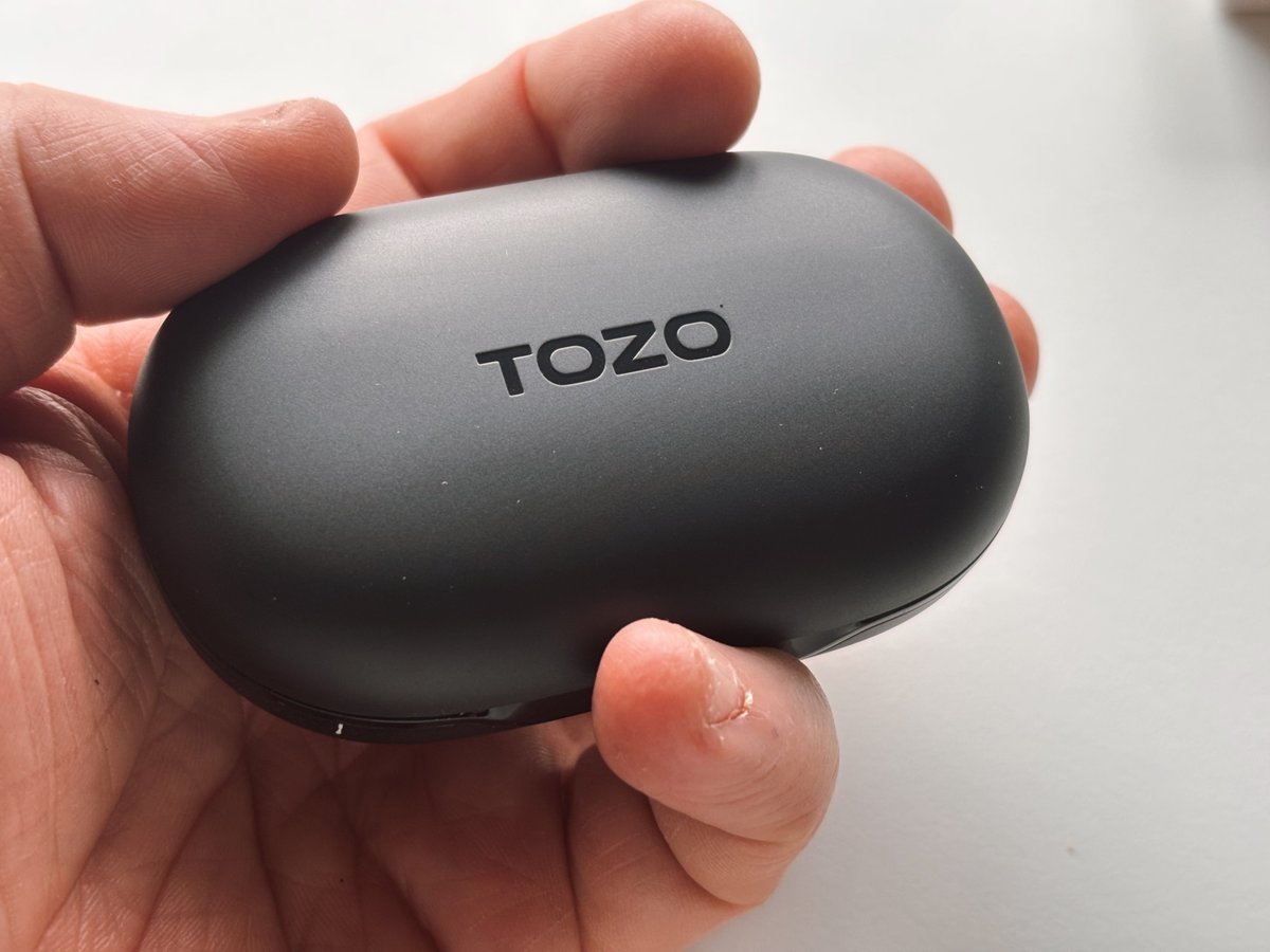 TOZO OpenWear charging case in hand close-up