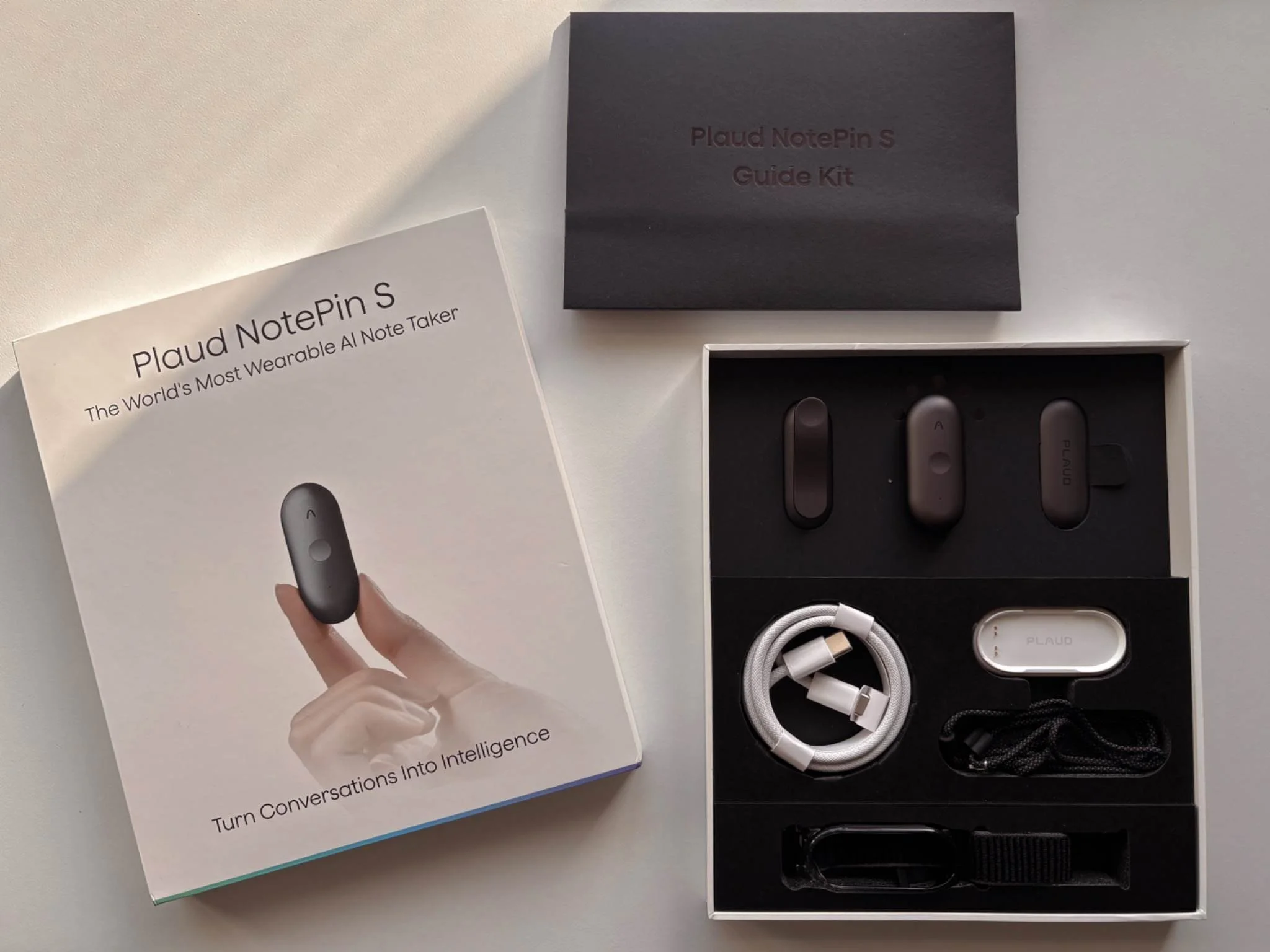 PLAUD NotePin S unboxing showing the premium packaging, NotePin S device, accessories, charging dock and USB-C cable.