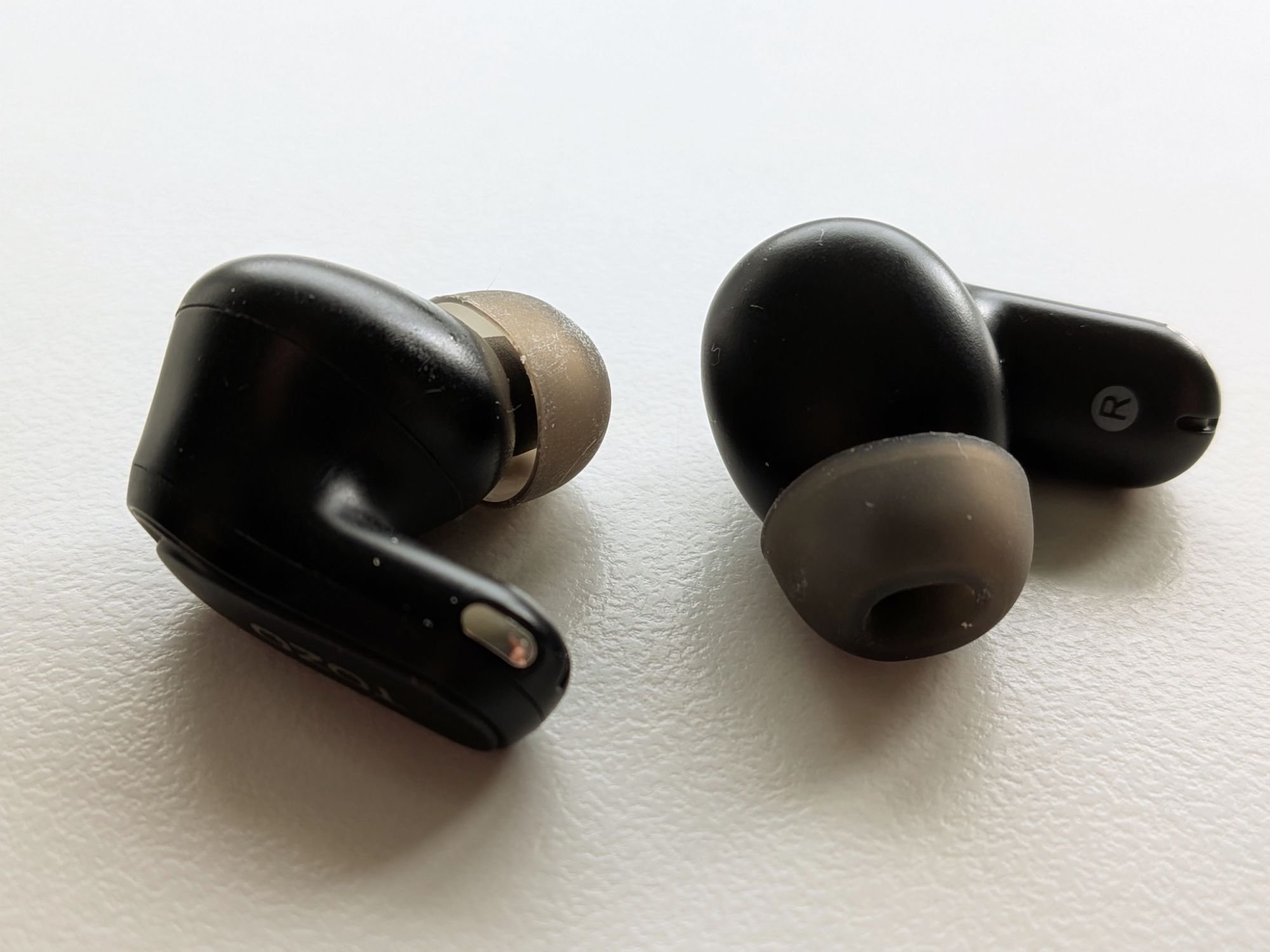 Close-up photo of the TOZO NC20 Pro wireless earbuds, showing the in-ear fit, silicone tips and compact stem design.