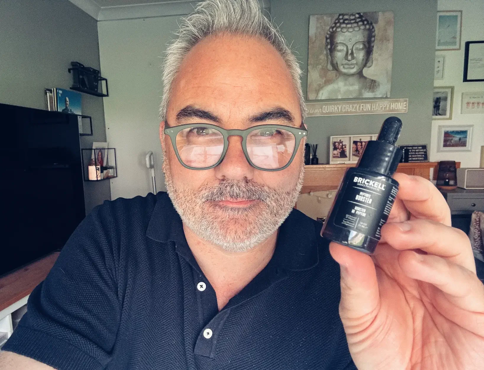 Jerome holding a bottle of Brickell Protein Peptides Booster for his 30-day skincare test.