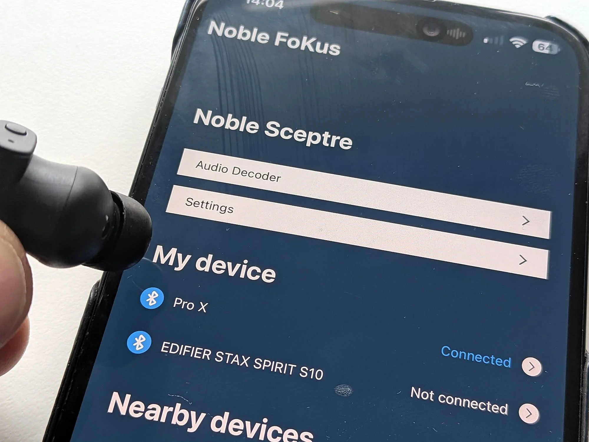 Noble Sceptre app screen on iPhone with an earbud in the foreground.