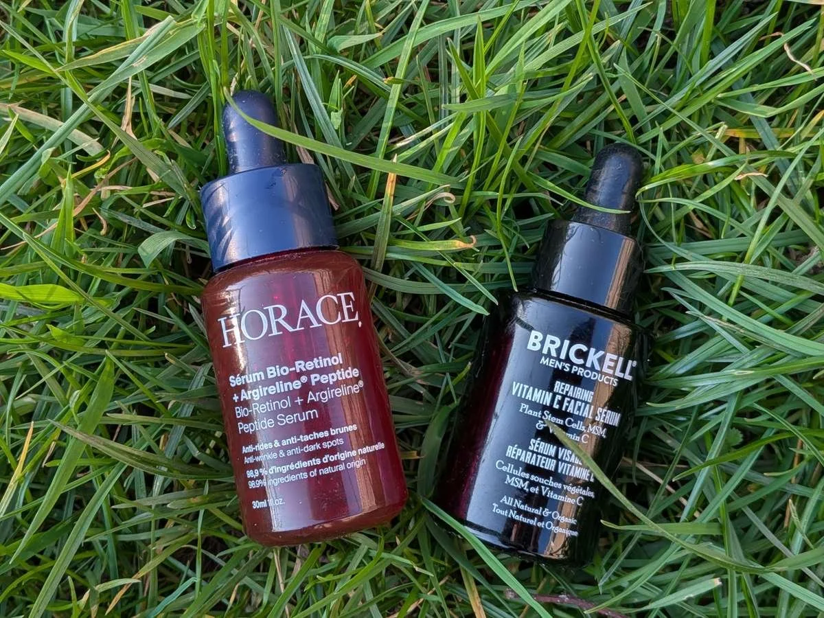 image comparing Horace Bio-Retinol + Argireline Peptide Serum and Brickell Repairing Vitamin C Facial Serum, photographed outdoors on grass for a men's skincare review.