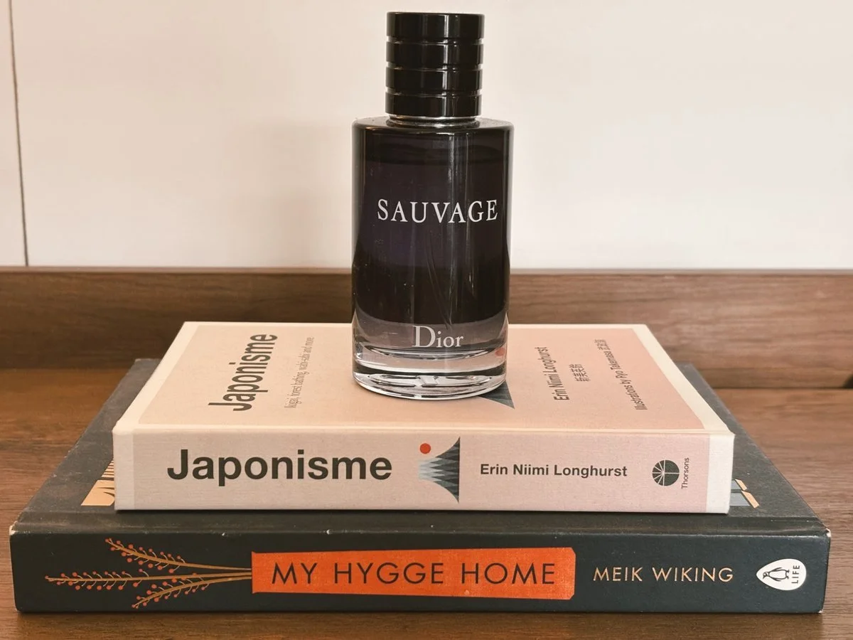 Sauvage by Dior cologne bottle placed on stacked books including My Hygge Home