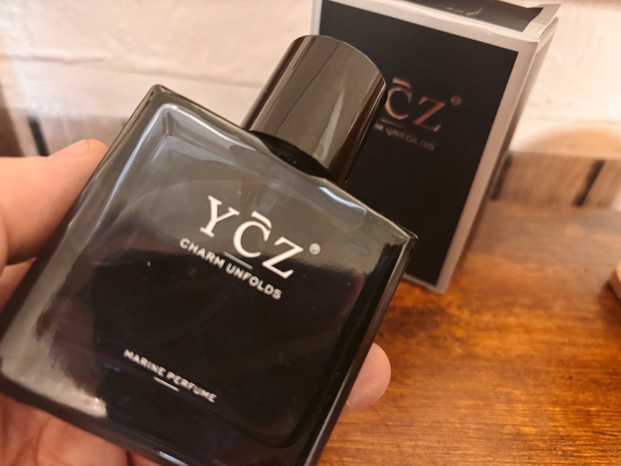 YCZ Midnight Marine marine perfume bottle held in hand with retail box in the background
