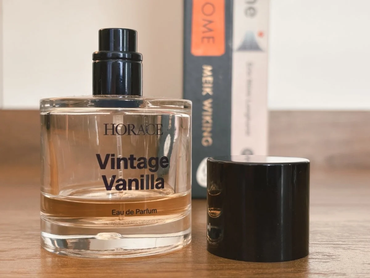 Horace Vintage Vanilla Eau de Parfum bottle on wooden table with cap beside it