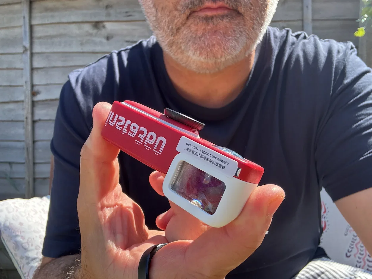 Jerome holding the tiny Insta360 GO 3S camera beside the red Retro Bundle Battery Pack