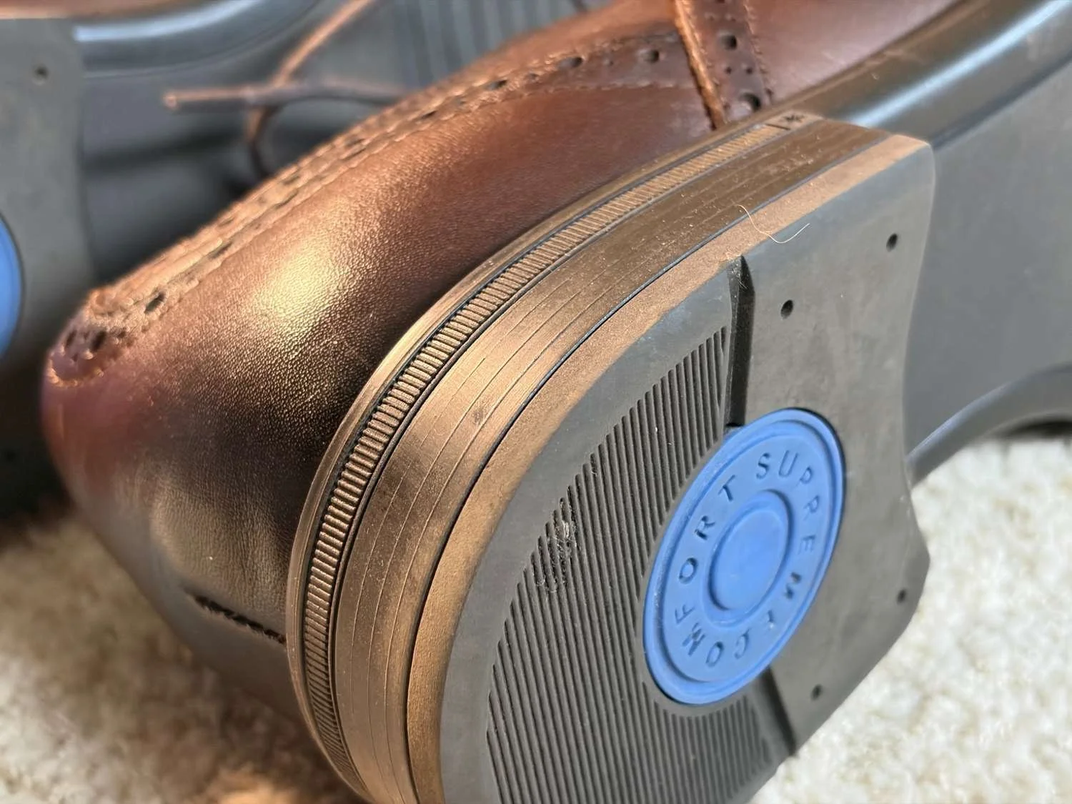 Close-up of the Bruno Marc brogue rubber outsole with textured tread and blue circular comfort marking on the heel.