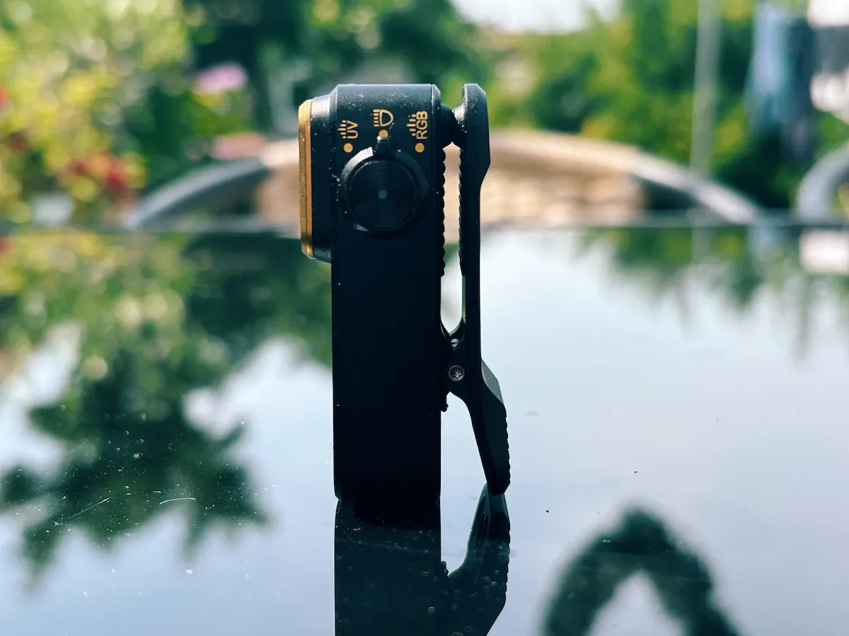 Side view of the Olight Oclip Pro S showing the built-in clip, mode icons and compact profile
