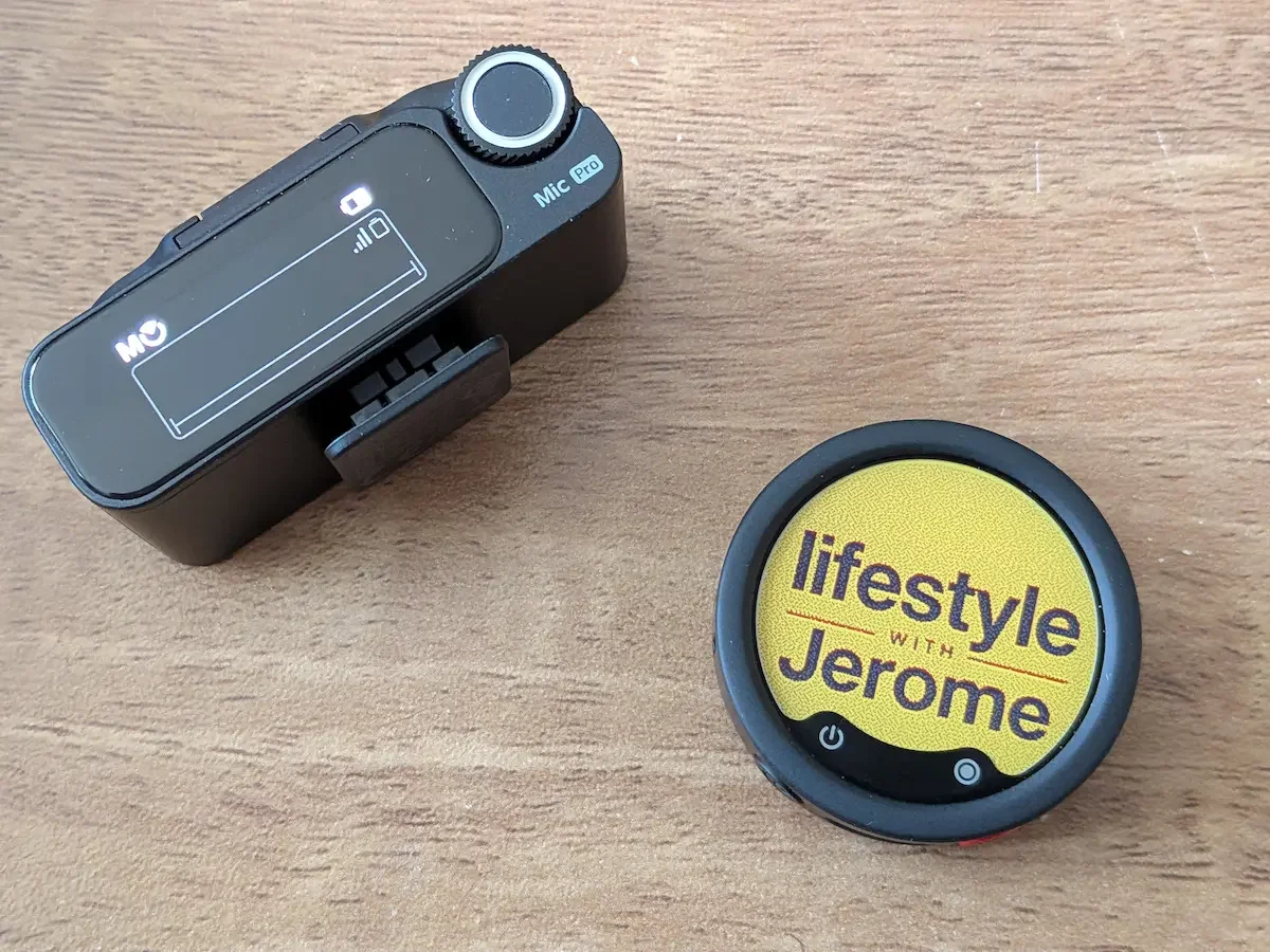 Insta360 Mic Pro receiver next to a personalised E-Ink display with the Lifestyle with Jerome logo on a wooden desk.