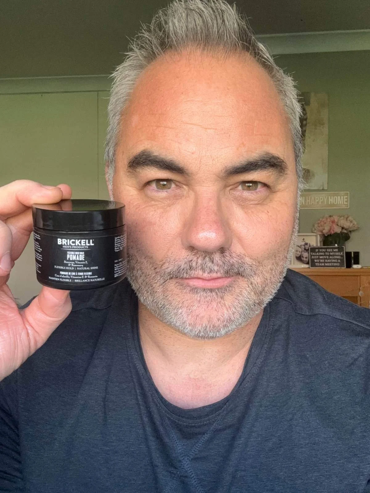Jerome holding Brickell Flexible Hold Wax Pomade after testing it on short hair.