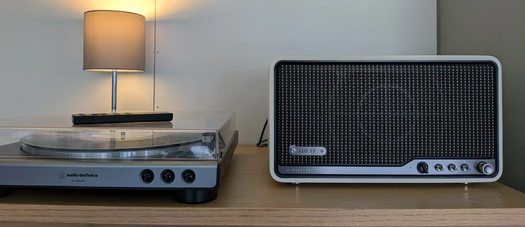 Edifier S300 tabletop speaker placed beside an Audio-Technica turntable in a stylish home listening setup.