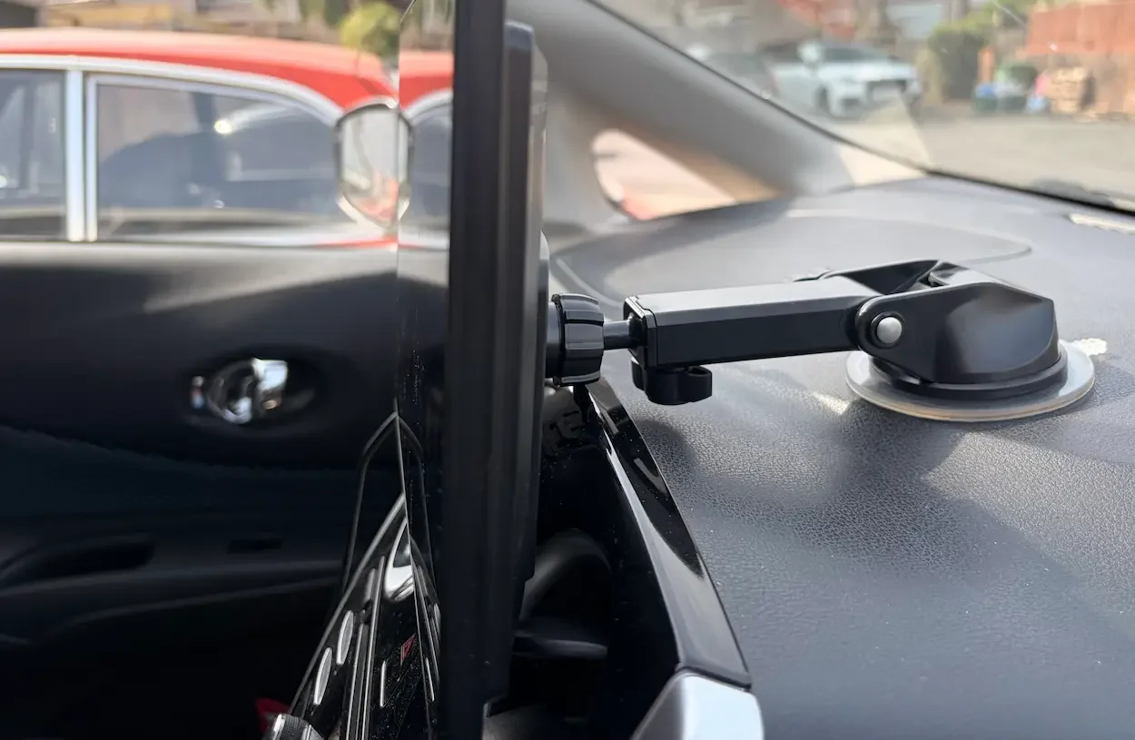 Side view of the LAMTTO CarPlay screen attached to a car dashboard using the supplied suction cup mount.